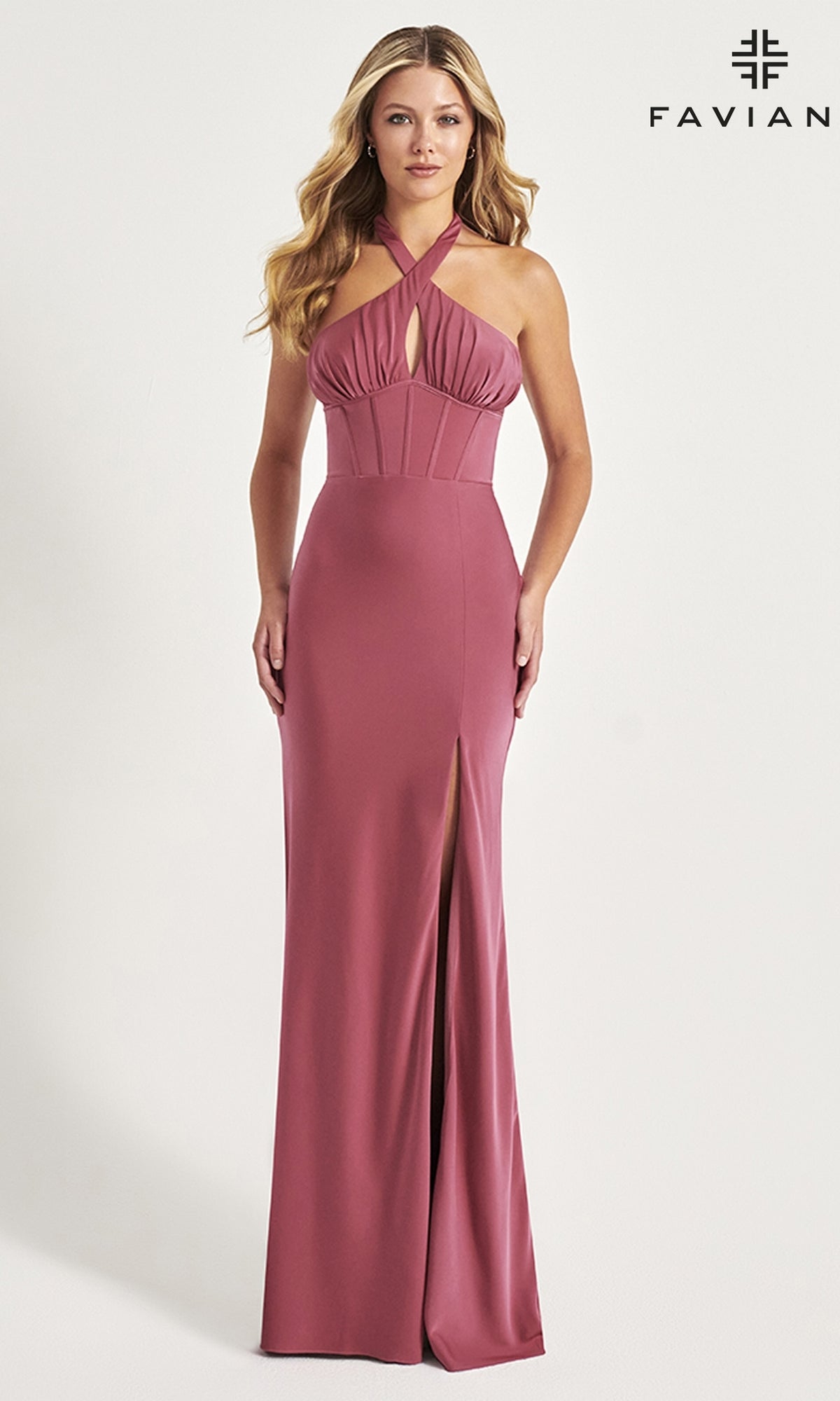 A woman poses against a plain background in the Faviana Corset-Waist Long Halter Prom Dress 11065, featuring a mauve color, keyhole cutout, fitted bodice, and thigh-high slit.